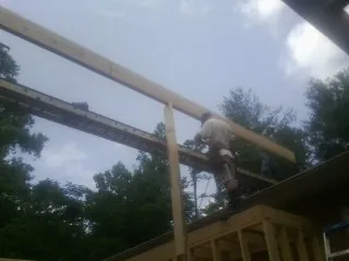 Carpenter setting a ridge beam over a new addition frame — Ice Dam Removal by Roofing Brothers in Robesonia