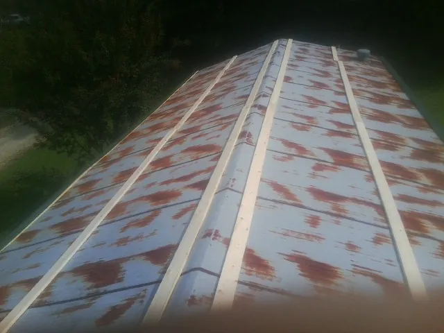 Rusted metal roof panels with new wood purlins before replacement — Storm Damage Roof Repair in Robesonia by Roofing Brothers