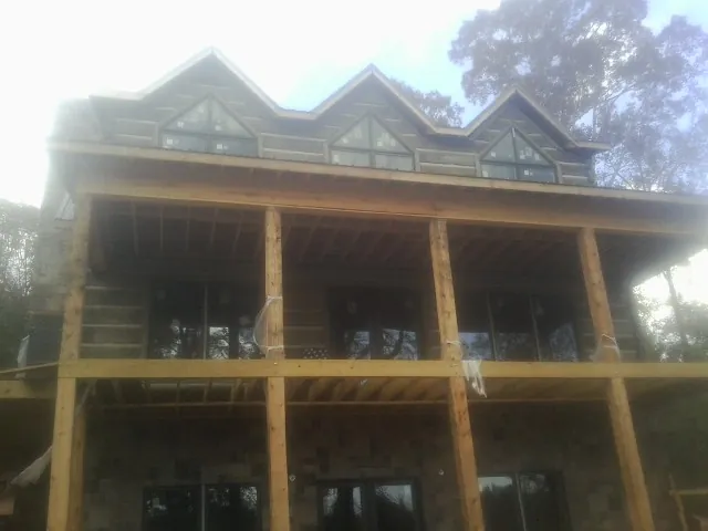 Dormers and porch framing on a large log home under construction — Roof Coating work by our crew in Robesonia