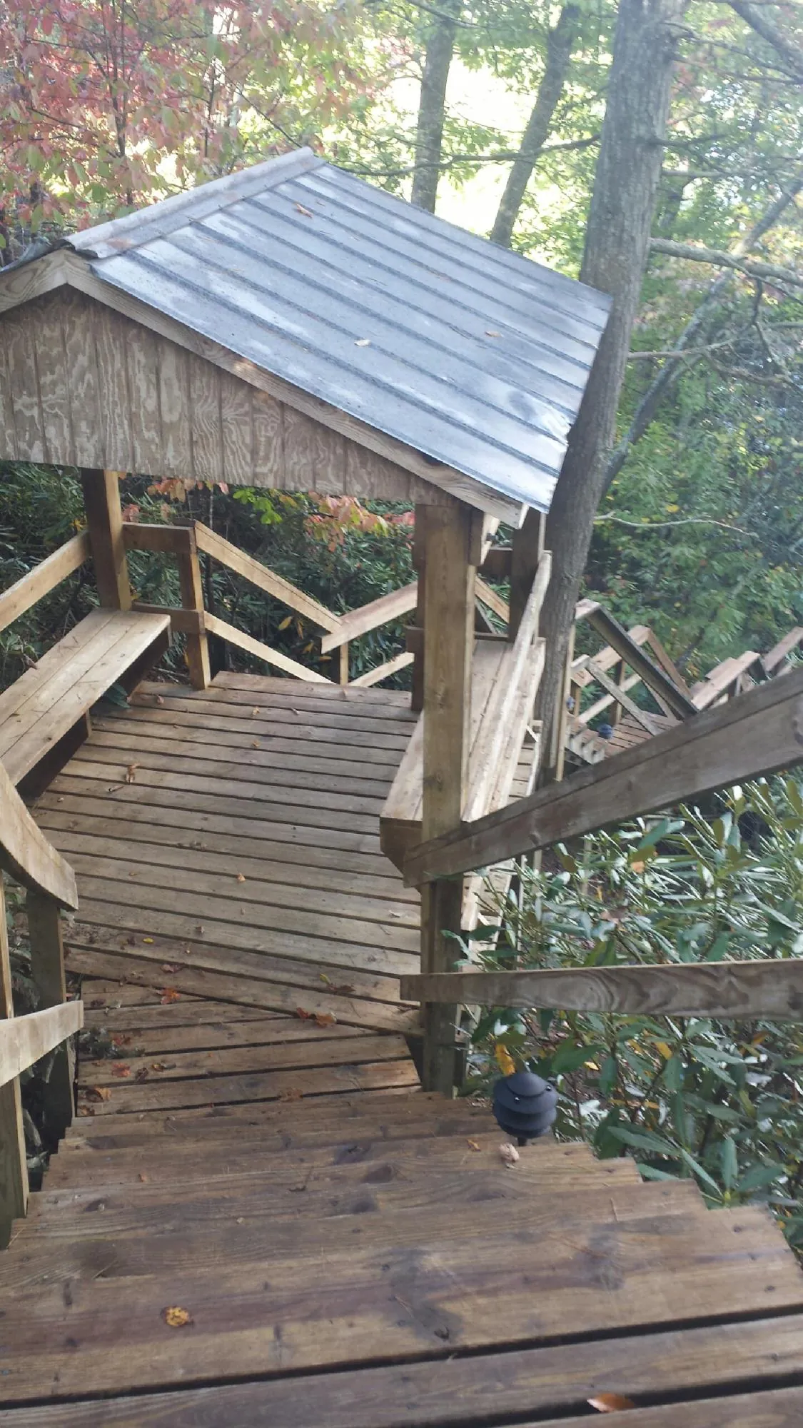 Metal roofed shelter over wooden steps on a wooded walkway — Skylight Repair & Installation work by our crew in Robesonia