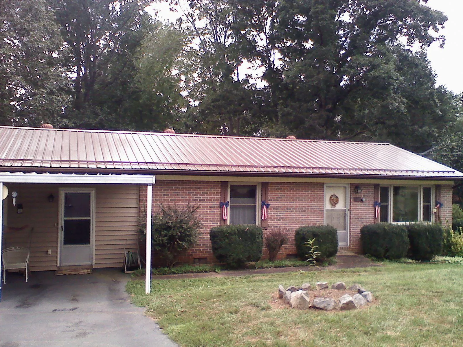 Bronze metal roof and carport on a brick ranch home — Roof Repair work by our crew in Robesonia